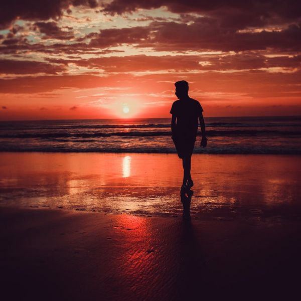 Person meditating peacefully in a calm natural environment at sunrise.